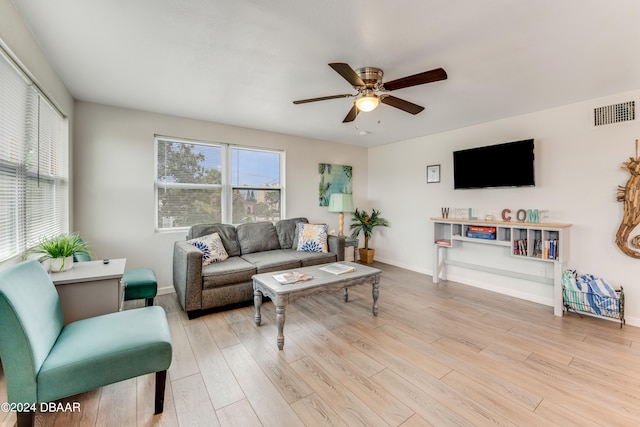 living room with light hardwood / wood-style flooring and ceiling fan