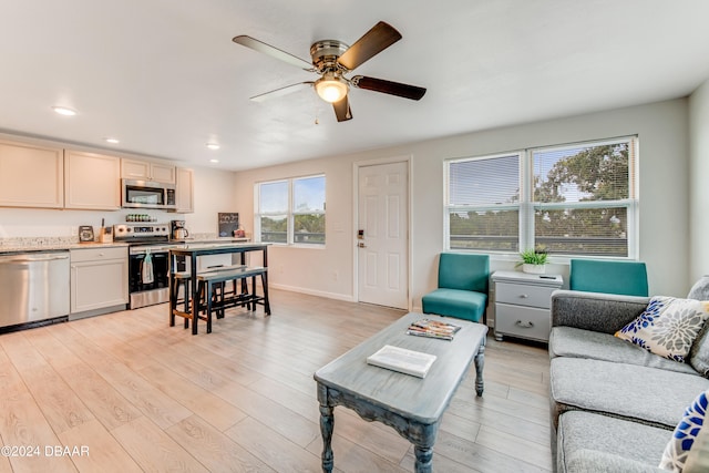 living room with ceiling fan and light hardwood / wood-style floors