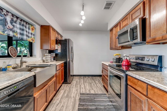 210 Centennial Ln, Daytona Beach, FL 32119 - kitchen featuring a sink, stainless steel appliances, brown cabinets, and visible vents