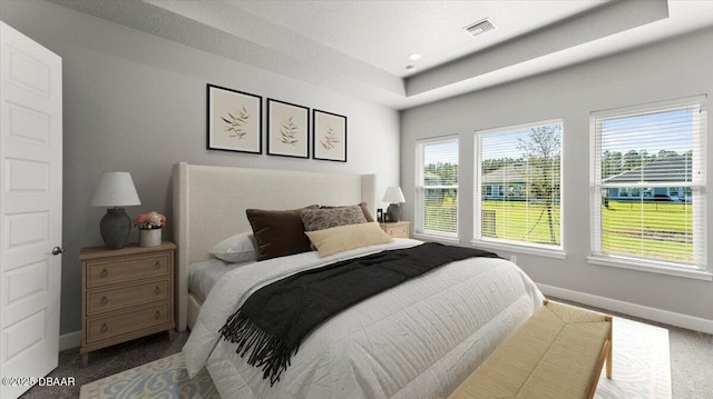 bedroom with visible vents, baseboards, multiple windows, and carpet flooring