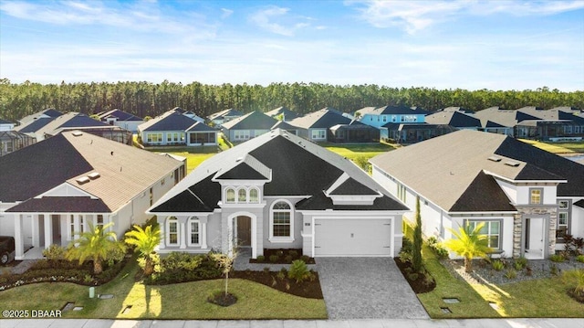 view of front of house with a residential view, a front yard, decorative driveway, and a garage