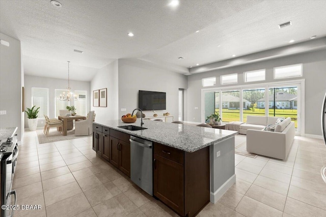 kitchen featuring visible vents, open floor plan, appliances with stainless steel finishes, an inviting chandelier, and a sink