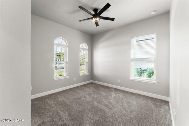 spare room featuring carpet flooring, baseboards, and ceiling fan