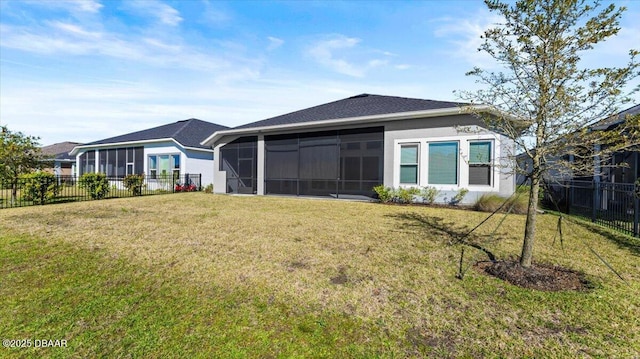 rear view of house featuring a lawn, fence private yard, and a sunroom