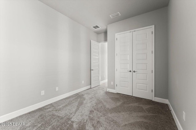 unfurnished bedroom with a closet, baseboards, visible vents, and carpet floors