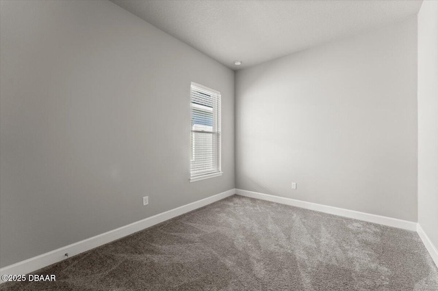 unfurnished room with carpet flooring and baseboards