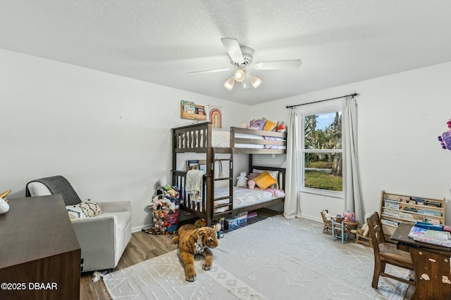 bedroom featuring ceiling fan, a textured ceiling, and light wood-type flooring