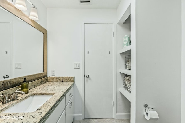 bathroom with vanity, baseboards, and visible vents