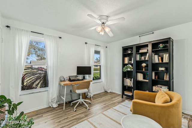 office space with a textured ceiling, ceiling fan, and light wood-type flooring