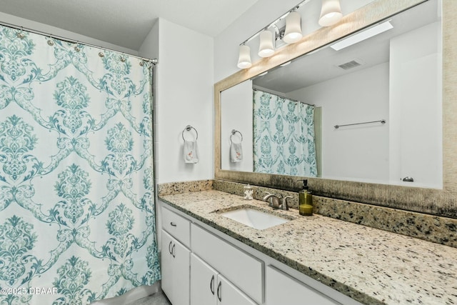 bathroom featuring vanity and curtained shower