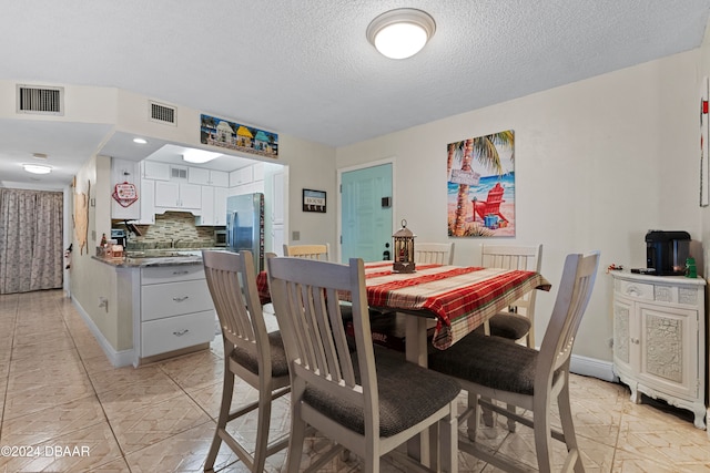 dining room featuring a textured ceiling