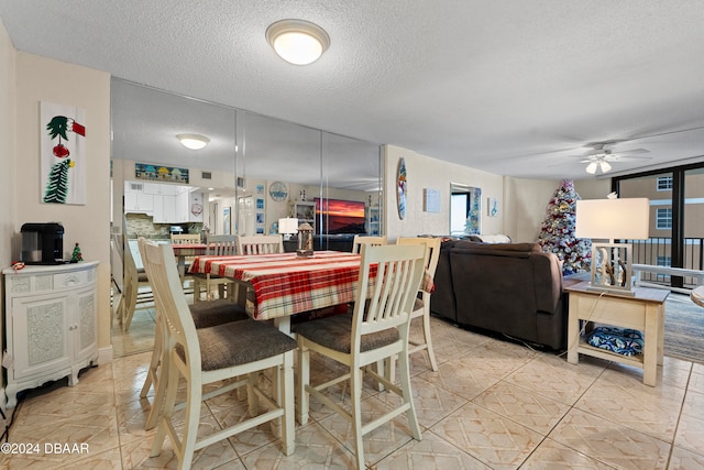 dining room with ceiling fan, light tile patterned floors, and a textured ceiling