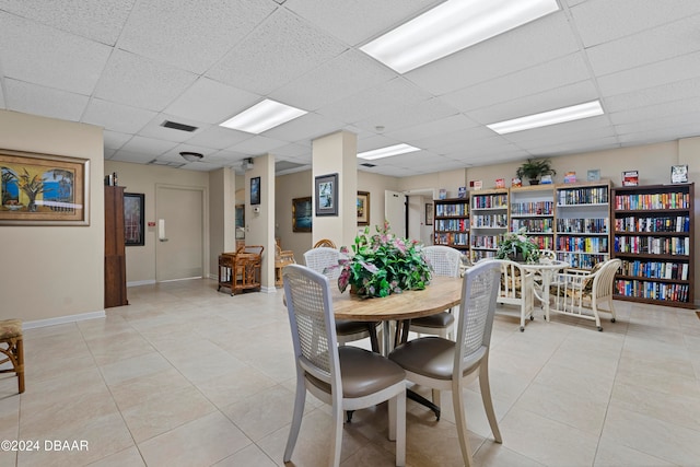 dining area featuring a drop ceiling and light tile patterned floors