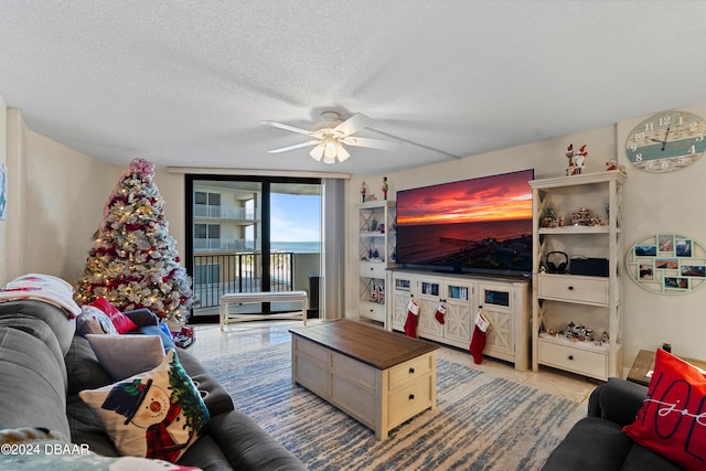 living room with ceiling fan and a textured ceiling