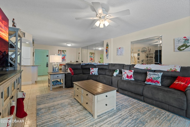 tiled living room with a textured ceiling and ceiling fan