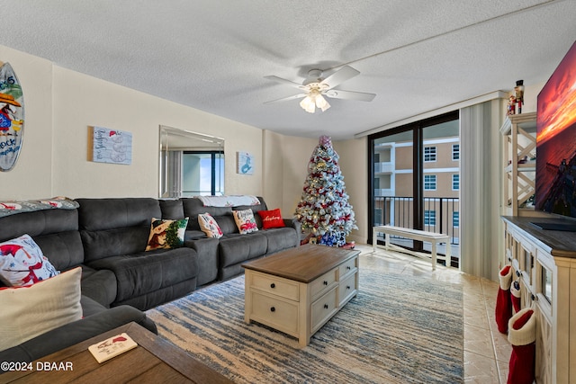 tiled living room with a textured ceiling, a wall of windows, and ceiling fan