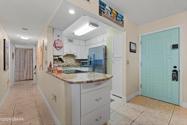 kitchen with black electric stovetop, light stone countertops, tasteful backsplash, white cabinetry, and stainless steel fridge with ice dispenser