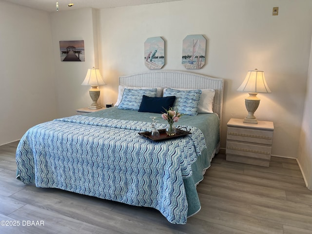 bedroom featuring wood finished floors and baseboards