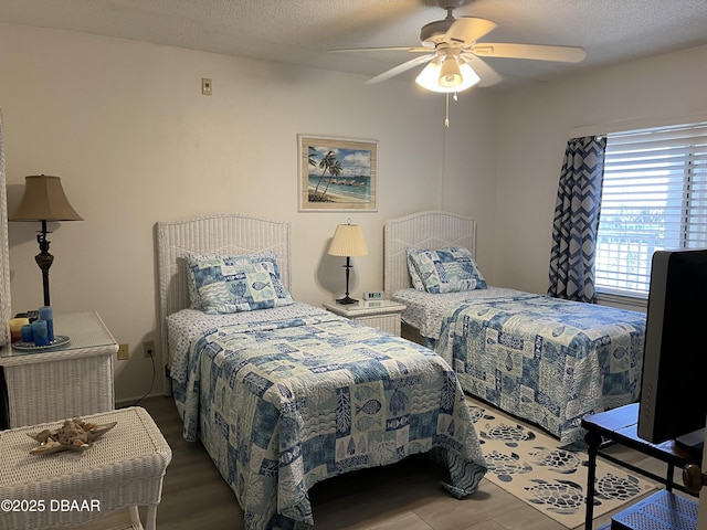 bedroom featuring ceiling fan, a textured ceiling, and wood finished floors