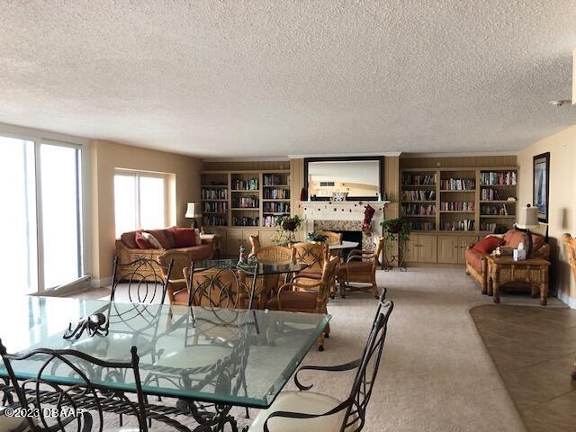 dining space featuring light colored carpet and a textured ceiling