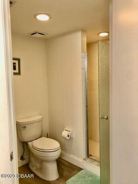 bathroom featuring hardwood / wood-style floors, toilet, and an enclosed shower