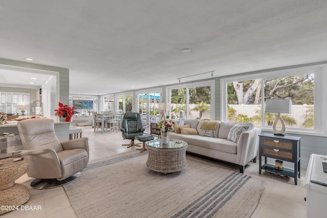 living room featuring a healthy amount of sunlight, light tile patterned flooring, and a textured ceiling