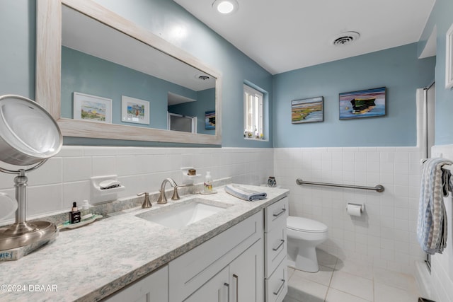 bathroom with tile patterned flooring, vanity, tile walls, and toilet