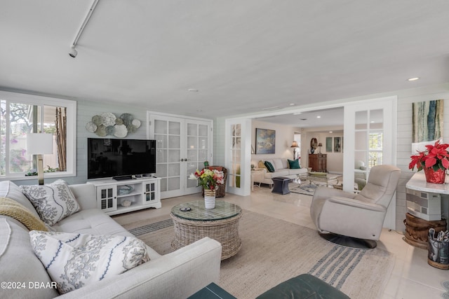 living room with french doors, light tile patterned floors, and plenty of natural light