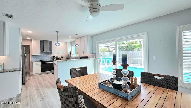 dining space with ceiling fan and light hardwood / wood-style floors