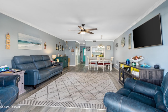 living room featuring ceiling fan with notable chandelier, hardwood / wood-style flooring, and ornamental molding