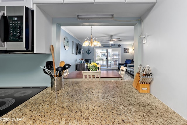 kitchen with decorative light fixtures, ceiling fan with notable chandelier, black electric cooktop, and ornamental molding