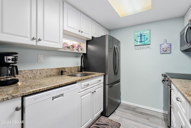 kitchen featuring sink, stainless steel appliances, light stone counters, white cabinets, and light wood-type flooring