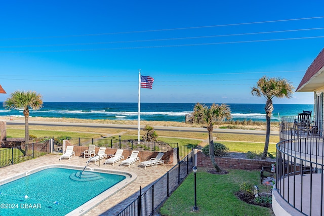 view of pool featuring a beach view, a water view, and a patio area