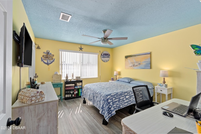 bedroom featuring hardwood / wood-style floors, ceiling fan, and a textured ceiling