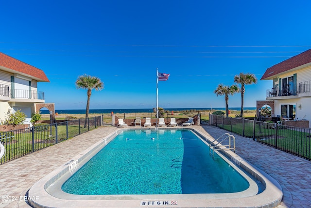 view of pool with a water view and a patio