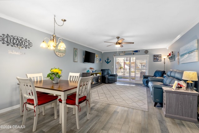 dining room with light hardwood / wood-style floors, ceiling fan with notable chandelier, and ornamental molding