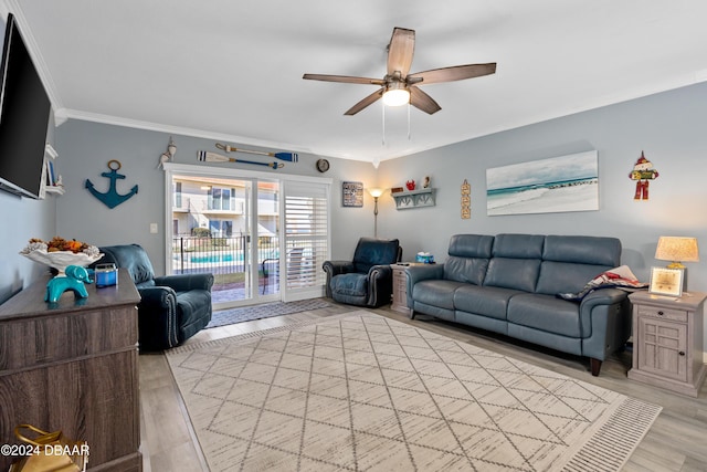 living room with crown molding, ceiling fan, and light wood-type flooring