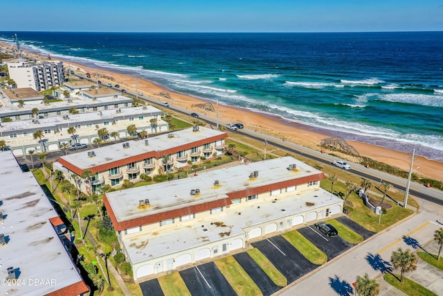 drone / aerial view featuring a beach view and a water view