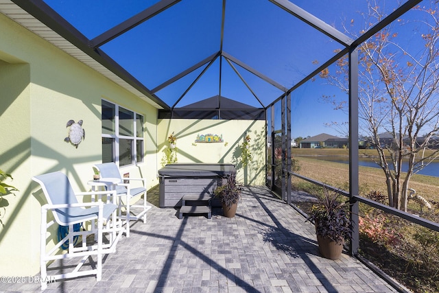 view of patio featuring a lanai and a hot tub