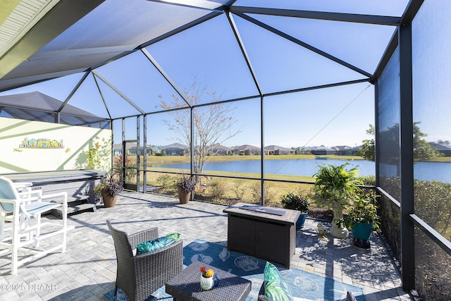 view of patio featuring a water view, a hot tub, outdoor lounge area, and glass enclosure