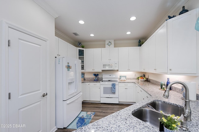 kitchen featuring white cabinetry, dark hardwood / wood-style floors, white appliances, light stone counters, and sink