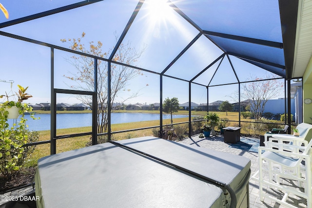 view of patio / terrace featuring glass enclosure and a water view