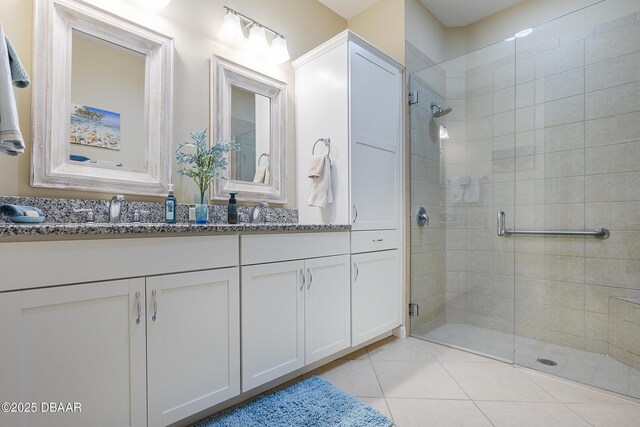 bathroom featuring a shower with shower door, vanity, and tile patterned floors