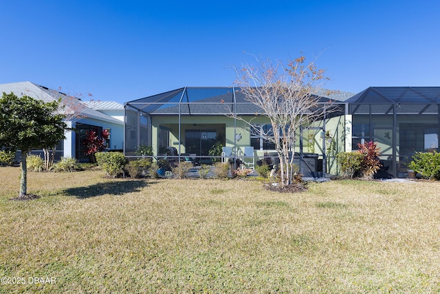 back of property with a lanai and a lawn