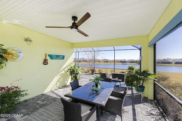 sunroom / solarium with a water view and ceiling fan