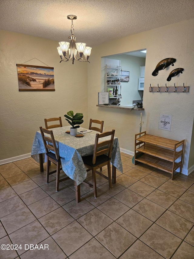 tiled dining area with a textured ceiling and an inviting chandelier