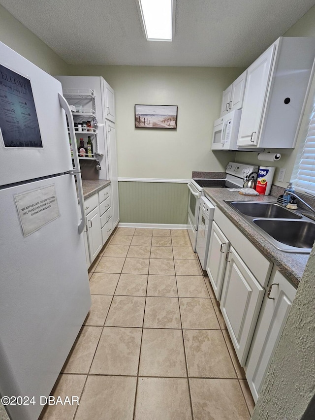 kitchen with white cabinets, white appliances, a textured ceiling, and sink