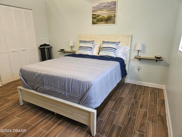 bedroom with dark hardwood / wood-style flooring and a closet