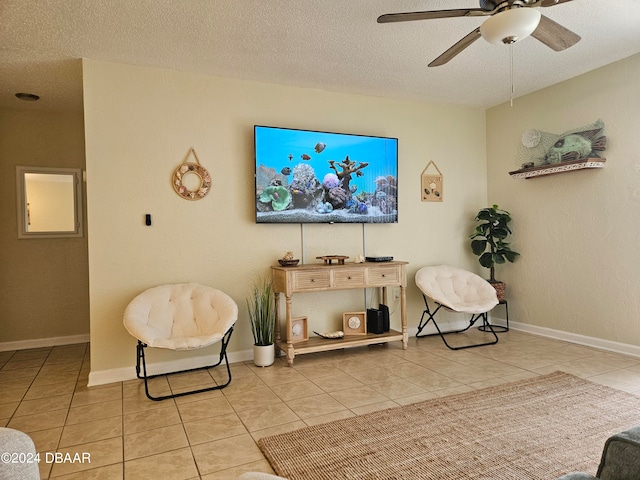 sitting room with a textured ceiling, ceiling fan, and light tile patterned floors