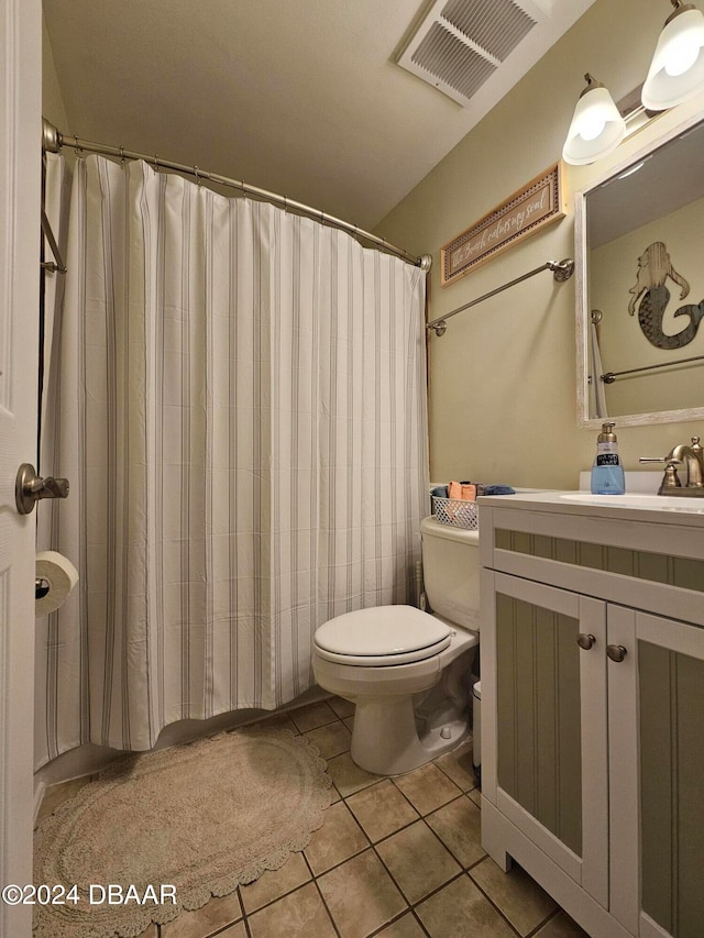 bathroom featuring vanity, tile patterned floors, and toilet